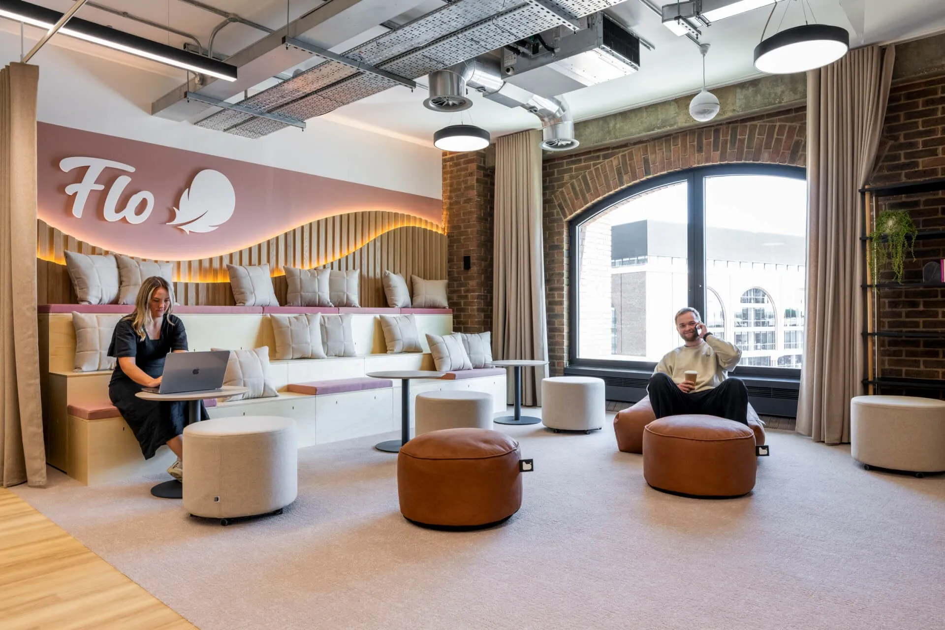 Two Flo employees working in a lounge area at the Flo office